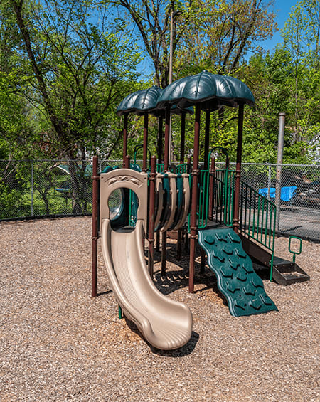 A playground with a slide and a green canopy.