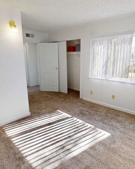 an empty room with a carpet and a door to a closet