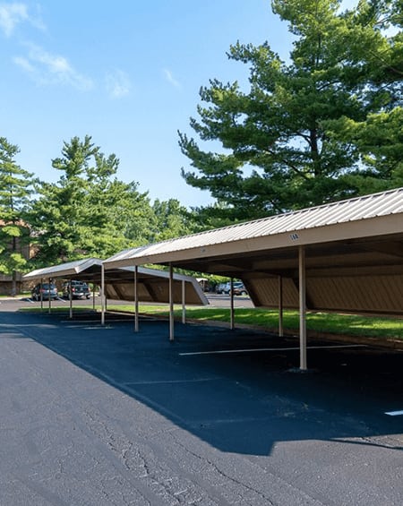 A parking lot with a long row of covered parking spaces.