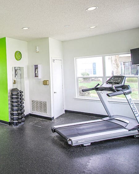 a workout room with a treadmill and a window