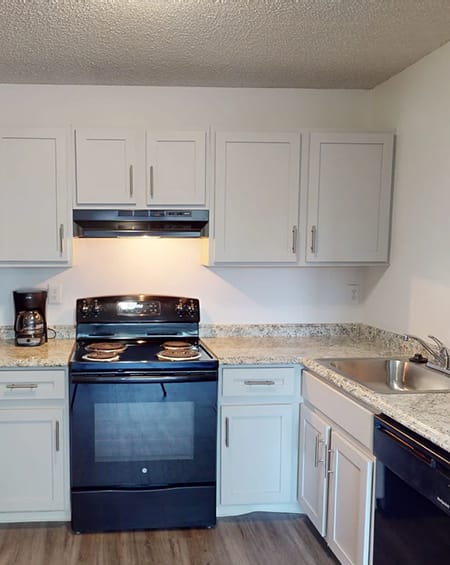 a kitchen with white cabinets and a stove and a sink