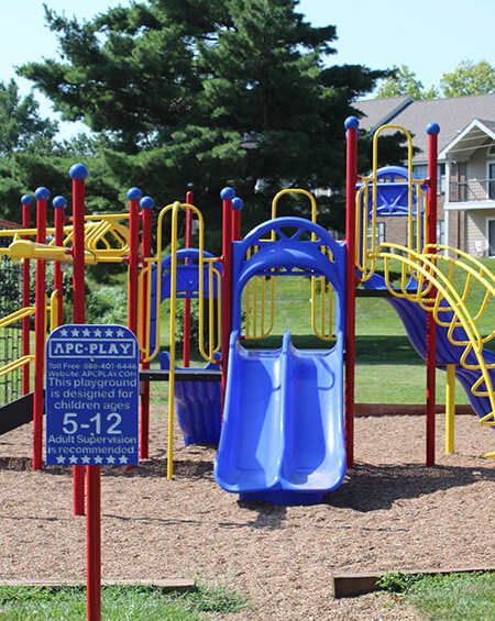 A playground with a blue slide and a sign that says ARC-PLAY.