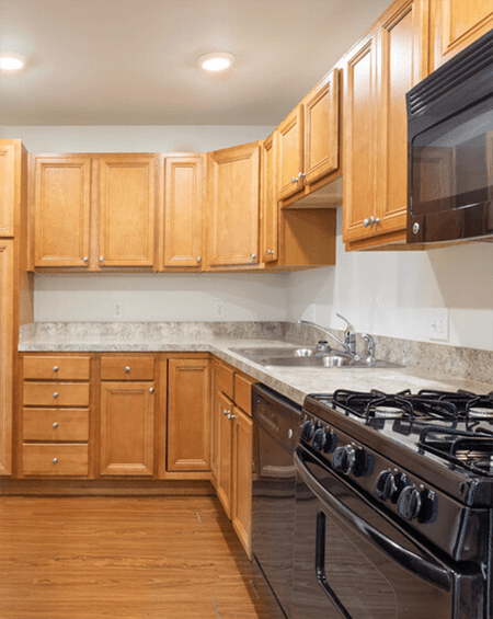 A kitchen with wooden cabinets and a black stove top.