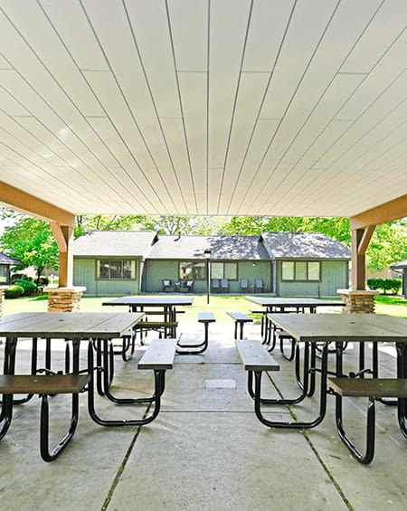 Picnic tables, benches, and grill under a covered pavillion