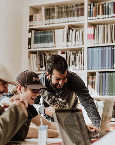 people in a library looking at a laptop