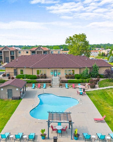 an aerial view of a swimming pool in front of a house