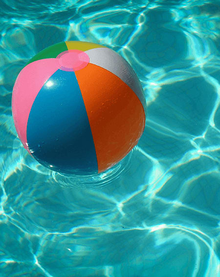 A beach ball floating in a pool of water.