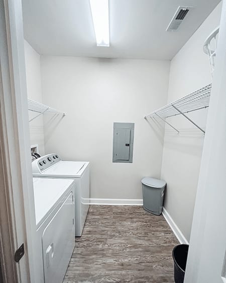 A small white bathroom with a toilet, sink, and a trash can.
