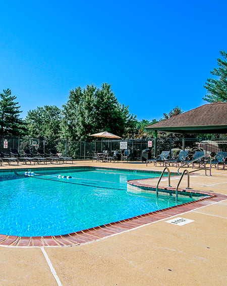 a resort style pool with chairs around it and a pavilion