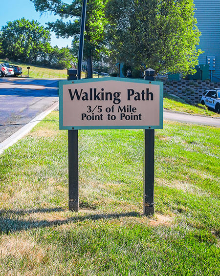 a walking path sign on the side of a road
