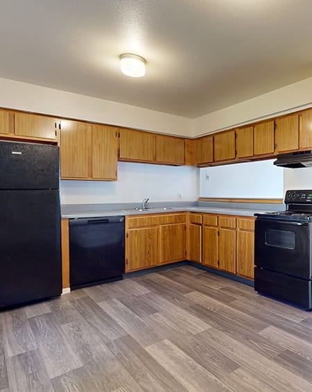 A kitchen with wooden cabinets and black appliances.