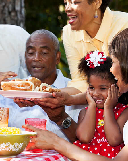 A family enjoying a meal together outdoors.