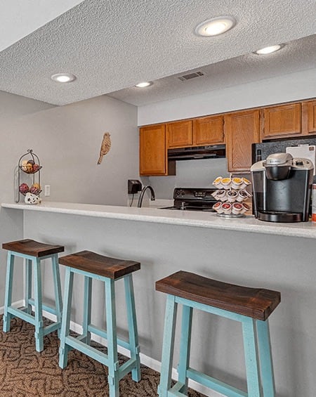 a kitchen with three stools and a counter top