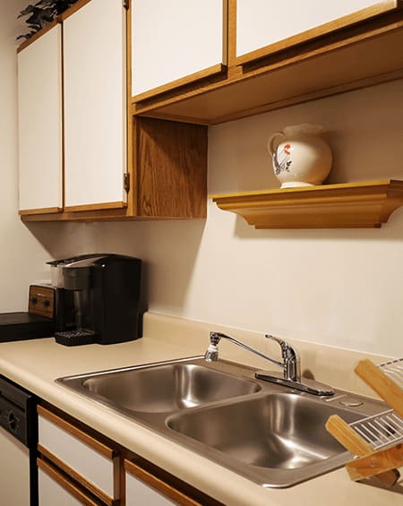 a kitchen with a sink and cabinets and a coffee maker
