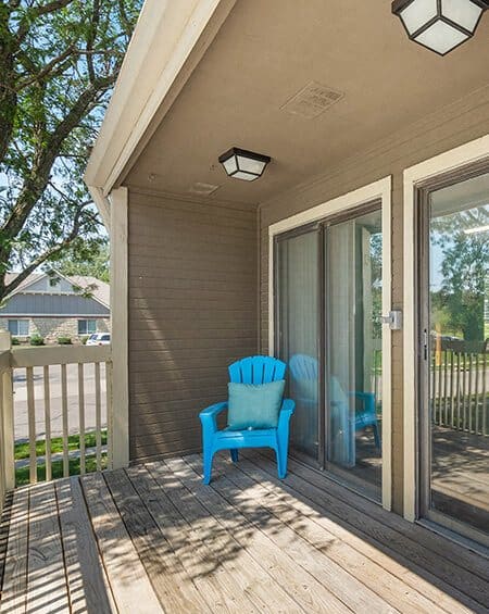 a blue chair is sitting on a porch