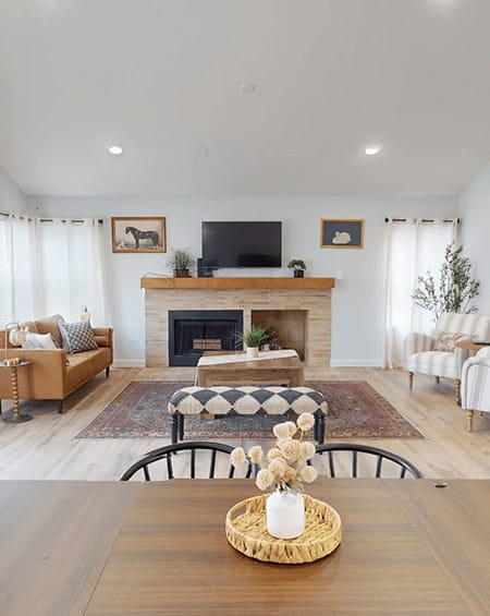 A living room with a fireplace and a television above it.
