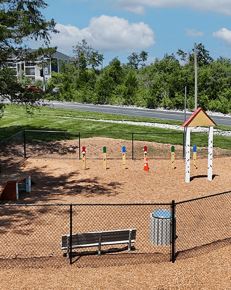 A playground with a swing set, slide, and a bench.