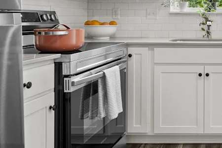 A modern kitchen with a stainless steel refrigerator, oven, and microwave.