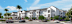 A large white building with a parking lot in front of it.