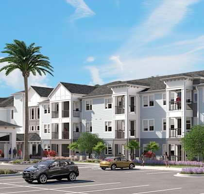 A large white building with a parking lot in front of it.