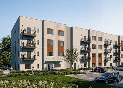 A modern apartment complex with cars parked in front.