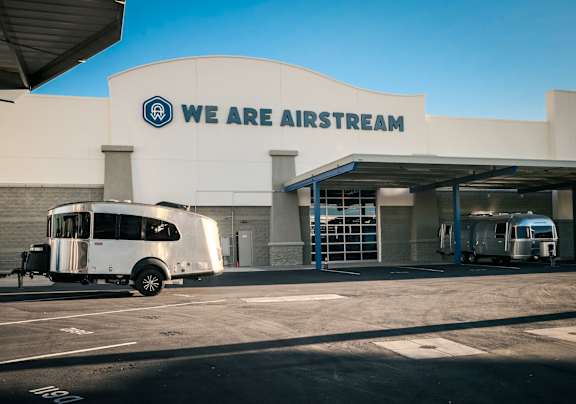 Airstream parked in front of a building with the sign "We are Airstream".