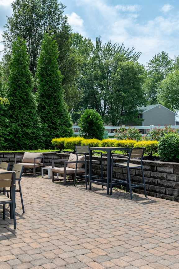 a patio with tables and chairs on a brick patio