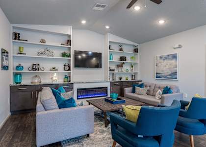 a living room with blue chairs and couches