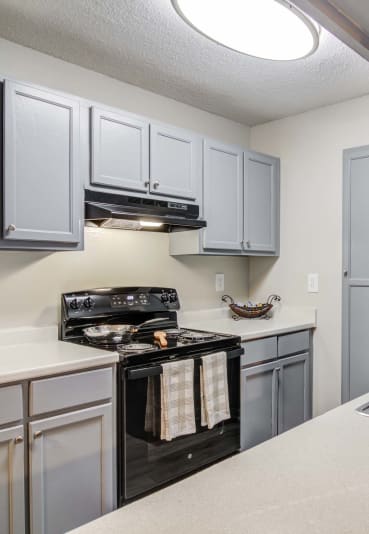 Flats at Riverview apartments in Duluth Georgia photo of a kitchen with white cabinets and black appliances