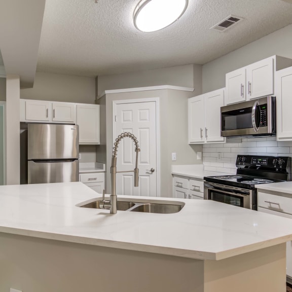 an open kitchen with white counter tops and a sink