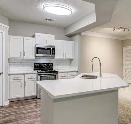 an empty kitchen with white cabinets and a white counter top