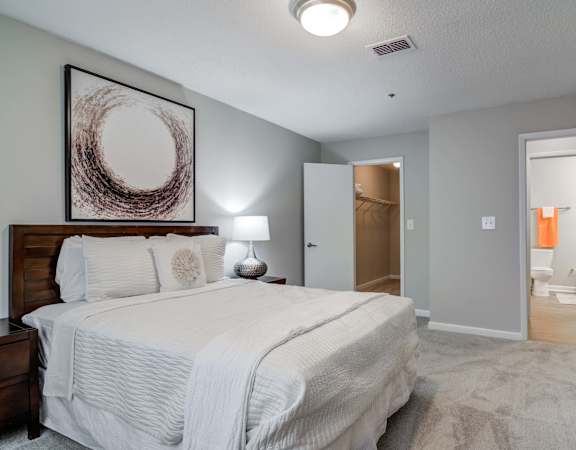 Flats at Riverview apartments in Duluth Georgia photo of a bedroom with a large bed and a dresser