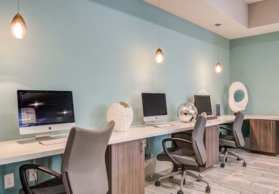 two desks with computers and chairs in a room