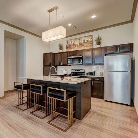 A kitchen at 35 Degrees North with stainless steel appliances and a large island with stools.