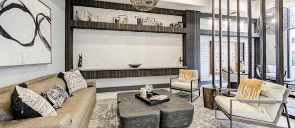 A modern living room with a grey sofa, a white chair, and a coffee table.