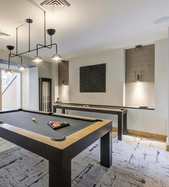 a billiards table in a game room with lights