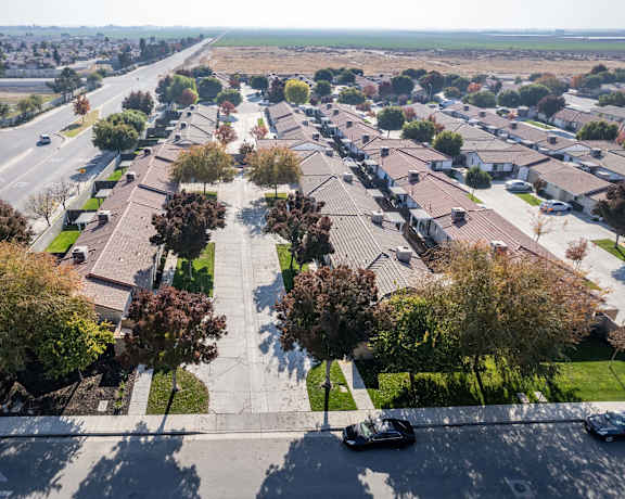 an aerial view of a parking lot with cars and trees