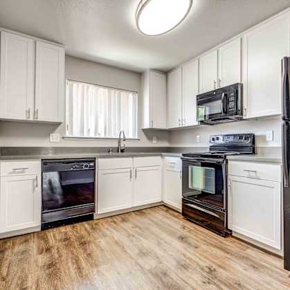 a kitchen with stainless steel appliances and white cabinets