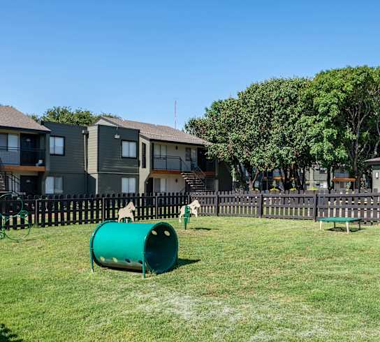 two children playing in a park in front of houses