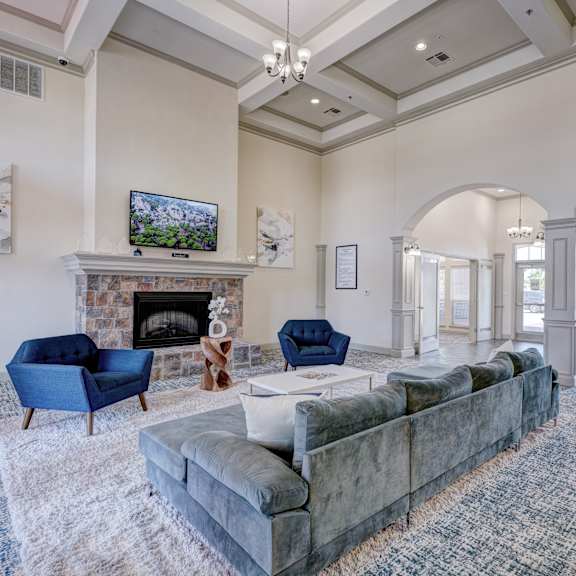 The front lounge with couches and chairs and a fireplace at Liberty Pointe. 