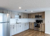 Thumbnail 11 of 14 - A modern kitchen with wooden cabinets and stainless steel appliances.