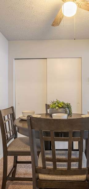 A dining room with a table and chairs.