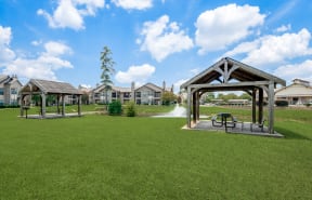a park with a fountain and benches in the grass