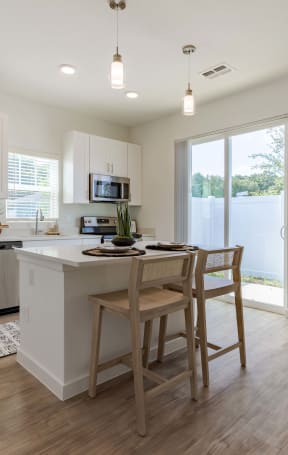 a kitchen with a center island and a stainless steel refrigerator