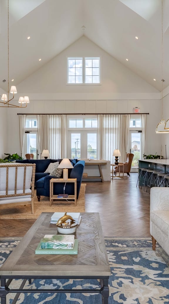 Furnished living room with high ceilings, large window, and stylish decor.