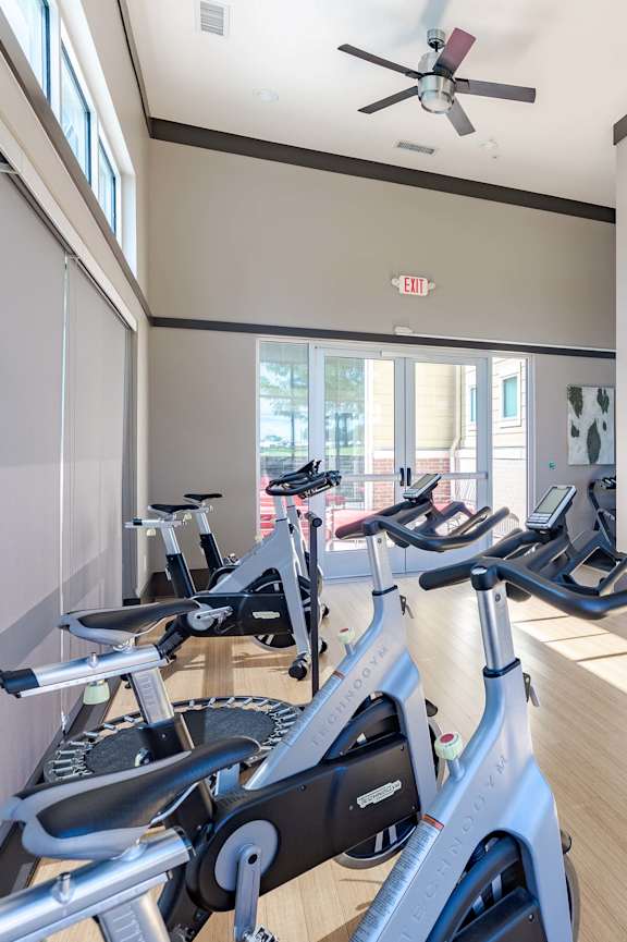 A gym with treadmills and a television.