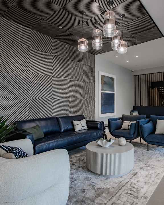 A modern living room with a black and white striped wall.