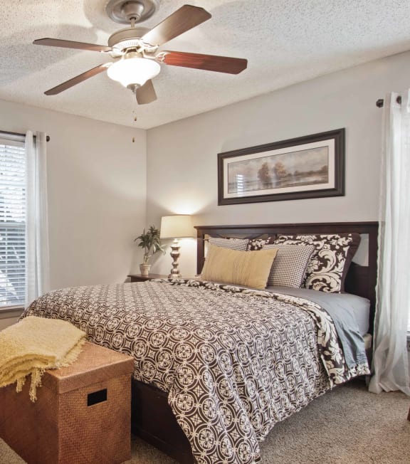 a bedroom with a bed and a ceiling fan
