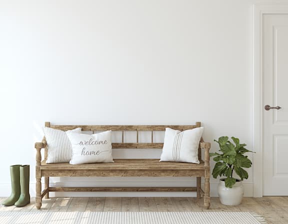 A living room with a green couch, a wooden table, and a painting on the wall.