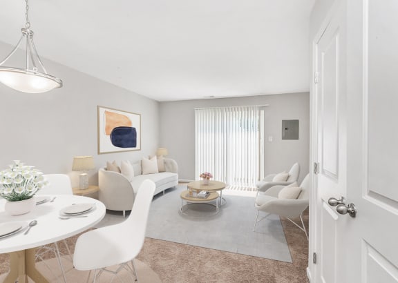a living room with white couches and chairs and a round table